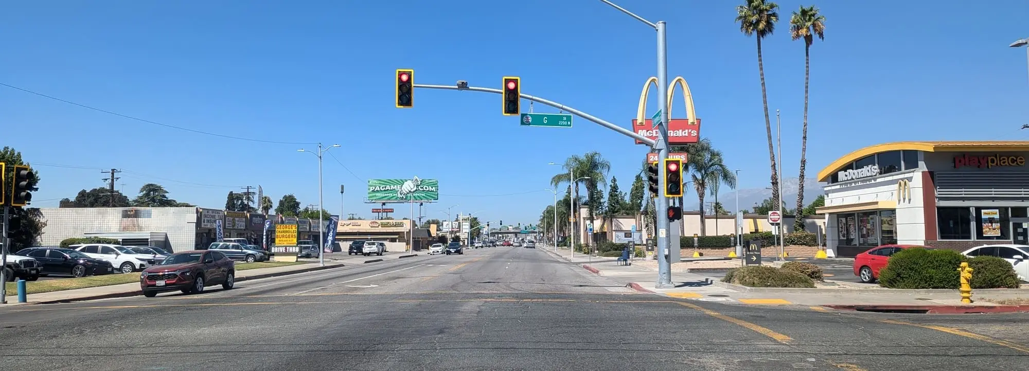 A bustling street view in San Bernardino, California, featuring houses and palm trees, representing areas where homeowners can sell their houses fast.